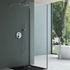 A modern bathroom with a shower and a bathtub, overlooking a garden. Produktbild-Vorschau