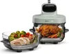 A Dreame Tasti AirFryer with a whole roasted chicken and vegetables in one glass container, and cooked chicken breast with vegetables in another glass container. Produktbild-Vorschau