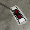 A mop with a telescopic handle and a microfiber pad is shown on a tiled floor. Produktbild-Vorschau