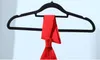 A red garment is hanging on a black hanger against a light blue background. Anteprima dell’immagine prodotto