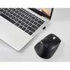 A black wireless ergonomic mouse is placed next to a silver laptop on a white surface. Produktbild-Vorschau