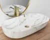 A marble sink with a gold faucet on a wooden surface. Podgląd zdjęcia produktu