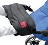 A person's hands wearing a black handwarmer are shown attached to a stroller handle. Produktbild-Vorschau