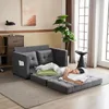 A woman is sleeping on a sofa bed in a living room. Produktbild-Vorschau