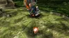 A small, pink, cartoonish character with red accents is running towards a large, metallic, broken-down machine in a grassy, outdoor environment. Produktbild-Vorschau