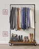 A metal garment rack with clothes hanging on it and shoes on the shelf below, with weight capacity indicators on the side. Náhled obrázku produktu