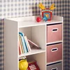 A white shelving unit with books and storage boxes against a blue and white checkered wall. Produktbild-Vorschau