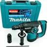 A Makita HR2811FT Kombihammer and its accessories are displayed on a white background, with the product's carrying case in the background. Podgląd zdjęcia produktu