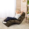 A woman relaxing on a floor chair in a room. Voir les images du produit
