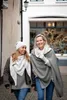 Two women walking and smiling in an outdoor alleyway. Produktbild-Vorschau