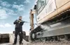 A man is pressure washing the tracks of a large construction vehicle outdoors. Voir les images du produit