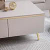 Close-up of a modern coffee table with drawers and gold legs, decorated with golden orbs. Náhľad obrázku produktu