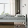 A bedroom scene with a white bed, bedding, curtains, and a bedside table. Produktbild-Vorschau
