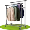 A double-tiered metal clothing rack with wheels, holding several shirts. Podgląd zdjęcia produktu
