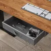 A close-up view of a desk drawer containing glasses, a pen, and a book. Voir les images du produit