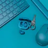 A teal-colored keyboard, mouse, and earbuds are arranged on a teal surface. Anteprima dell’immagine prodotto