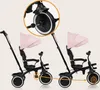 Two pink and black tricycles are shown side-by-side, with a magnified view of the front wheel of one. Produktbild-Vorschau