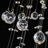 Close-up of crystal balls hanging from thin wires against a black background. Produktbild-Vorschau