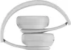 A close-up side view of white Beats Solo 4 wireless headphones folded. Produktbild-Vorschau