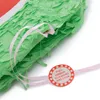 A close-up view of a green piñata with pink ribbons and a red and white circular tag. Produktbild-Vorschau