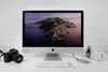 A desk setup with an iMac, keyboard, mouse, camera, external hard drive, and a mug. Anteprima dell’immagine prodotto