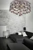 A modern living room with a dark sectional sofa, a dark coffee table, and a unique chrome chandelier. Podgląd zdjęcia produktu