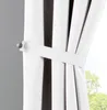 A close-up view of a white curtain held back by a tie-back. Produktbild-Vorschau