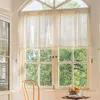 A window with curtains and a chair in a room, with trees visible outside. Produktbild-Vorschau