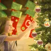 A young girl is decorating a Christmas tree with fillable ornaments. Produktbild-Vorschau