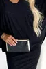 A close-up shot of a woman holding a black clutch bag. Anteprima dell’immagine prodotto