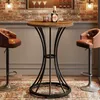 A bar area with a round table and two bar stools, featuring a bottle of liquor and a glass on the table. Produktbild-Vorschau