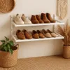 A shoe rack with various shoes displayed on shelves against a light-colored wall. Produktbild-Vorschau