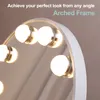 A close-up view of a makeup mirror with lights, showing its arched frame and the reflection in the mirror. Produktbild-Vorschau