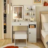 A vanity table with a mirror, stool, and storage, set up in a bedroom next to a bed. Anteprima dell’immagine prodotto