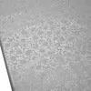 A close-up, angled view of a silver tablecloth with a floral pattern. Produktbild-Vorschau
