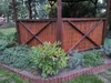 A garden gazebo with a bamboo screen and surrounding plants. Produktbild-Vorschau