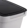 A close-up view of the top corner of a gray plastic trash can with a black lid. Produktbild-Vorschau