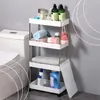 A white four-tier shelving unit filled with bathroom items, placed next to a toilet. Podgląd zdjęcia produktu