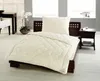 A bedroom scene with a bed made up with a cream-colored duvet and pillow. There is a bedside table with a lamp and some papers on it, and a plant in a pot. Produktbild-Vorschau