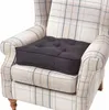 A dark grey seat cushion is placed on a beige and blue plaid armchair. Náhled obrázku produktu
