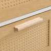 A close-up view of a drawer handle and the rattan texture of a cabinet. Podgląd zdjęcia produktu