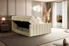 A bedroom scene with a beige upholstered bed with its storage compartment open, showcasing the mattress and frame. The room is decorated with modern furniture and soft lighting. Produktbild-Vorschau