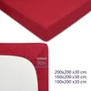 A close-up of a red fitted sheet, showing the elasticized corner and a measurement indicator. Produktbild-Vorschau