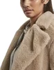 Close-up of a woman wearing a beige sherpa coat. Produktbild-Vorschau