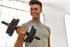 A man is lifting a dumbbell indoors. Náhľad obrázku produktu