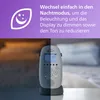 A split image showing a baby monitor in a dimly lit room on the left and a brighter room on the right, with text overlay describing its night mode features. Produktbild-Vorschau