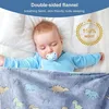 A baby sleeping under a blanket with dinosaur patterns. Produktbild-Vorschau