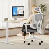A woman is sitting at a desk and working on a computer. Produktbild-Vorschau