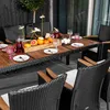 An outdoor dining set with chairs and a table laden with fruit and drinks. Náhľad obrázku produktu