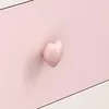 A close-up shot of a pink heart-shaped drawer knob on a pink surface. Náhľad obrázku produktu